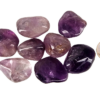 A pile of large amethyst tumbled stones with deep purple, to violet hues with a quarter for comparison. Most are larger than the quarter.