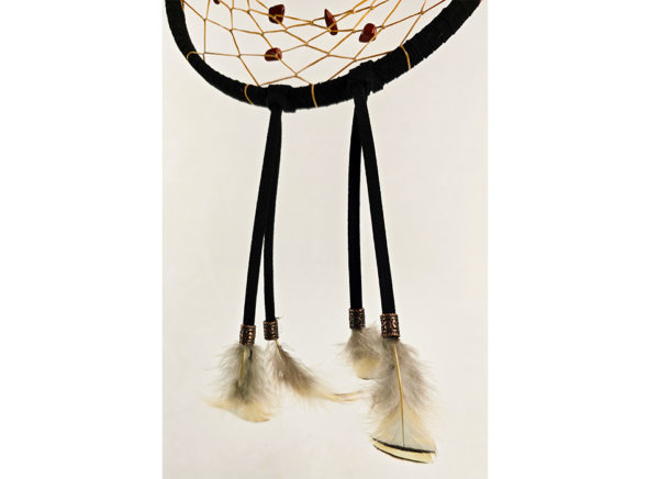Feathers hanging from a dream catcher held on by copper beads.