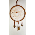 A light brown dream catcher with baltic amber as the centerpiece, surrounded by smaller brown stones woven in, draped with feathers.