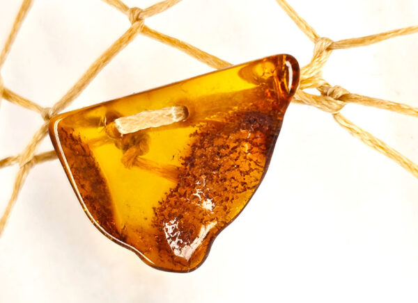 A closeup of baltic amber on a dream catcher.