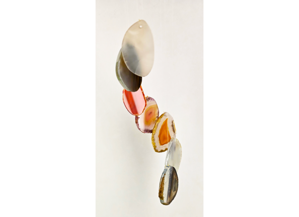 A closeup of multicolored agate slices hanging from a windchime.