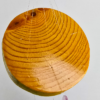 An agate windchime displaying the wood base that is polished and shows the rings in the wood, and a shiny finish.