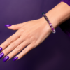 An amethyst bead bracelet displayed on a womans wrist.