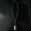 Aquamarine pendant with light blue, creamy yellowish white flowing through the polished stone, with a wire-wrapped silver bail displayed with a full silver necklace on a black table.
