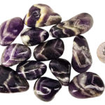 A pile of medium chevron amethyst polished stones, with deep purple to violet, with white in chevron patterns on the stones, and a quarter for comparison. Most are the same size or larger than the quarter.