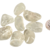 A pile of large quartz tumbled stones, that are mostly transparent with some inclusions, with a quarter for comparison. All are larger than the quarter.