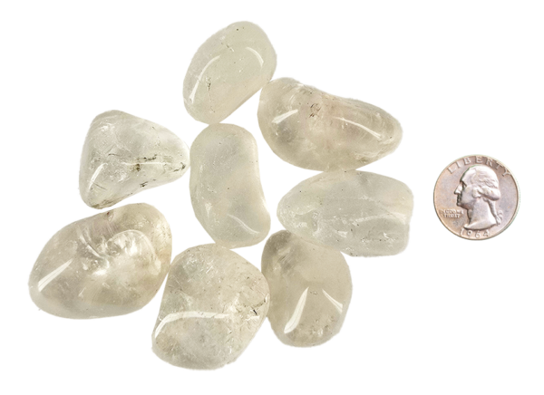 A pile of large quartz tumbled stones, that are mostly transparent with some inclusions, with a quarter for comparison. All are larger than the quarter.