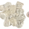 A pile of medium quartz tumbled stones, that are mostly transparent with some inclusions, with a quarter for comparison. Most are larger than the quarter, some the same size or slightly smaller.