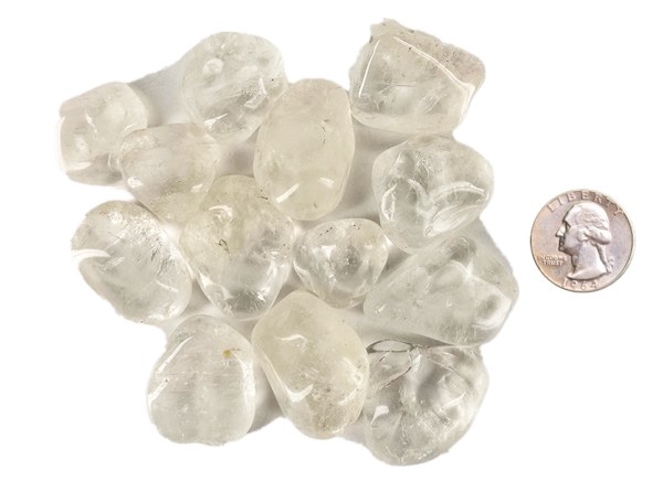 A pile of medium quartz tumbled stones, that are mostly transparent with some inclusions, with a quarter for comparison. Most are larger than the quarter, some the same size or slightly smaller.