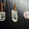Two quartz pendants with copper wire wrapped bails with a quarter for size comparison. Each crystal is slightly larger than the quarter.