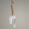 A quartz crystal pendant drilled that has a copper wire wrapped bail.
