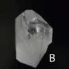 Large clear quartz crystal point with black backround, labeled 'B'.