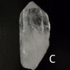 Large clear quartz crystal point with black backround, labeled 'C'.