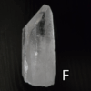 Large clear quartz crystal point with black backround, labeled 'F'.