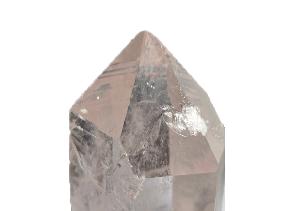Closeup of a large clear quartz point showing a small ding on the face of a point from mining.