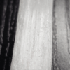 A closeup of a selenite stick, showing the fiber-like strands with a soft white glow.