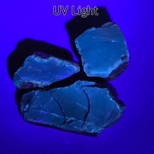 Three chunks of Indonesian Amber under a UV light that reveals a green tint.