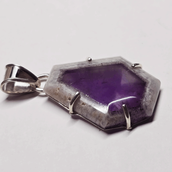 Atomic amethyst pendant with sterling silver posts securing stone, and a bail.