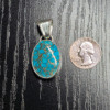 Sterling silver turquoise pendant with copper matrix with a quarter for comparison.